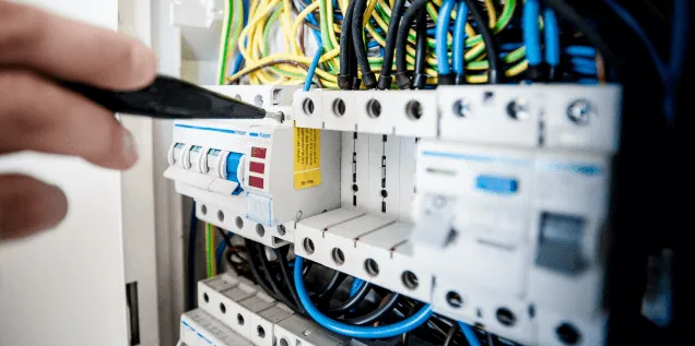 Revisión de un tablero eléctrico por un técnico de ANSIMA